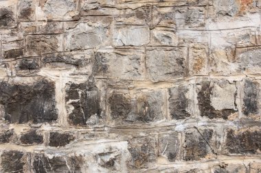 Yıpranmış dokusu ve doğal desenleri olan taştan bir duvar..