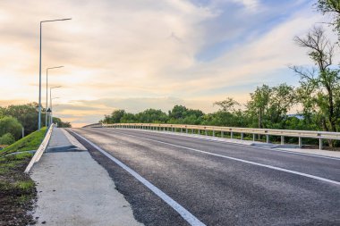 Gün batımında ufka uzanan huzur dolu boş bir yol..