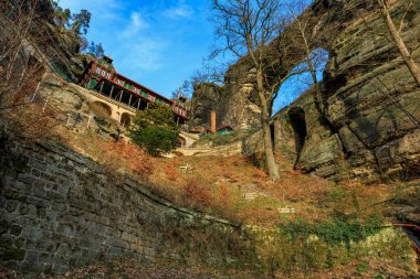 Tarihsel kaya kesimi kale inzivası, yüksek uçurumlar ve canlı sonbahar yaprakları arasında..
