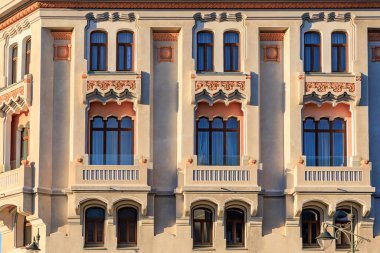 Dekoratif pencereleri ve dekoratif detaylarıyla zarif tarihi bina cephesi.