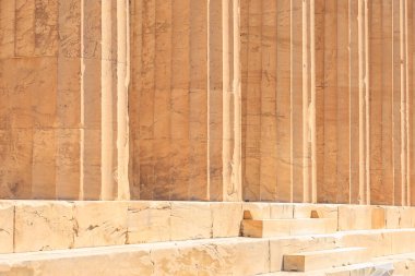 Duvar taştan yapılmış ve pürüzlü bir dokusu var. Duvar kahverengi ve Atina 'da Akropolis gibi yıpranmış görünüyor.