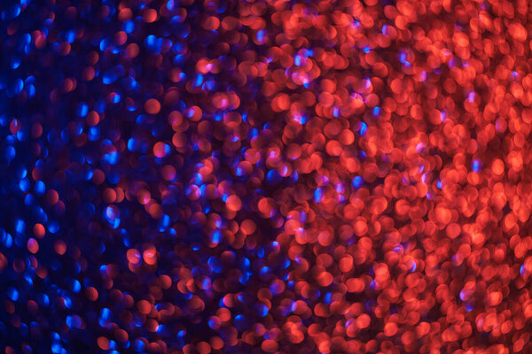 A blurry image of red and blue dots. The image has a dreamy, ethereal quality to it, with the red and blue colors blending together in a way that creates a sense of movement and energy