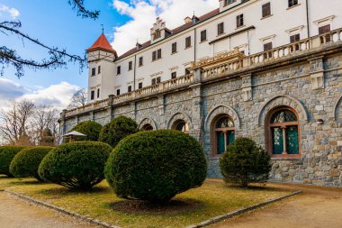 Bulutlu bir günde taş mimarisi ve manikürlü bahçeleri olan tarihi Avrupa kalesi.