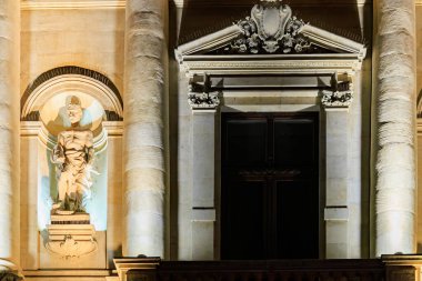 Tarihi bina cephesinde aydınlatılmış taş heykel ile süslü bir barok mimari. 8 Mart 2025 Bükreş Romanya.