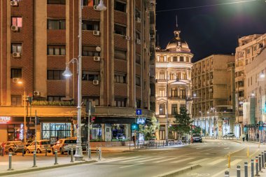 Aydınlatılmış sokakları ve binaları olan tarihi şehir mimarisinin gece görüşü. 8 Mart 2025 Bükreş Romanya.