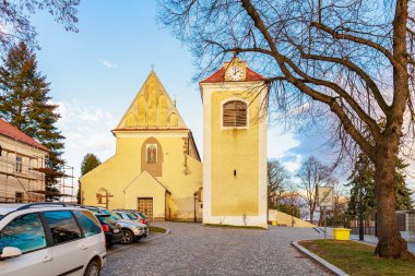 Huzurlu şehir merkezinde saat kulesi olan tarihi Avrupa kilisesi. 17 Mart 2025, Benesov, Çek Cumhuriyeti.