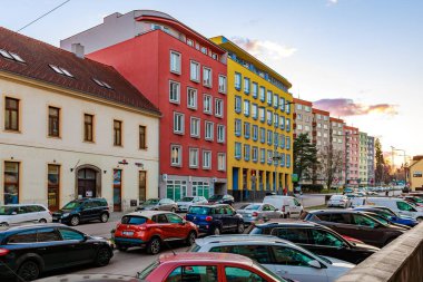 Canlı şehir caddesi, renkli binalar ve gün batımında trafik. 17 Mart 2025, Benesov, Çek Cumhuriyeti.