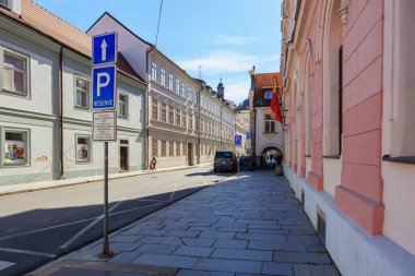 Otoparkı ve tarihi binaları olan sakin bir Avrupa sokak manzarası. 21 Mart 2025, Ceske Budejovice, Çek.