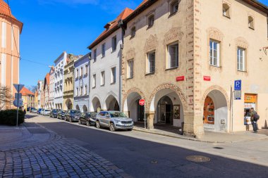 Avrupai tarihi cadde, kemerli cepheleri ve park edilmiş arabaları var. 21 Mart 2025, Ceske Budejovice, Çek.