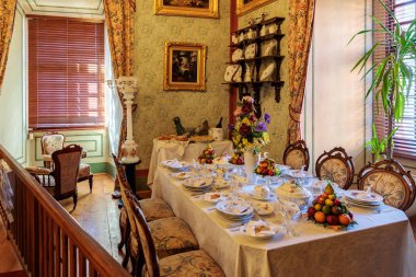 Çiçek aranjmanları ve meyve sergisi olan seti sehpası ve klasik dekoru olan kaliteli bir yemek odası. 20 Mart 2025, Cesky Krumlov, Çek.