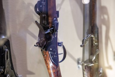 Antik çakmaklı tüfeğin yakın çekimi karmaşık mekanizmalar ve ahşap stoklar sergiliyor. 20 Mart 2025, Cesky Krumlov, Çek.