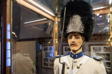 Tarihi askeri üniforma, ayı postu şapkası ve madalyalarla müze sergisinde sergileniyor. 20 Mart 2025, Cesky Krumlov, Çek.