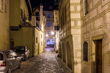 Sıcak sokak lambalarıyla aydınlatılan tarihi gece Avrupa sokağı. 20 Mart 2025, Cesky Krumlov, Çek.