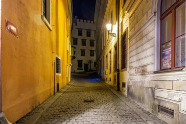 Tarihi binalarla dolu dar kaldırım taşları boyunca sessiz bir akşam yürüyüşü. 20 Mart 2025, Cesky Krumlov, Çek.