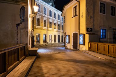 Tarihi mimarisi ve sıcak ışıklandırması olan tuhaf bir gece sokak sahnesi. 20 Mart 2025, Cesky Krumlov, Çek.