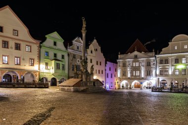 Cesky Krumlov 'un aydınlatılmış mimarisi ile tarihi kasaba meydanının gece manzarası. 20 Mart 2025, Cesky Krumlov, Çek.