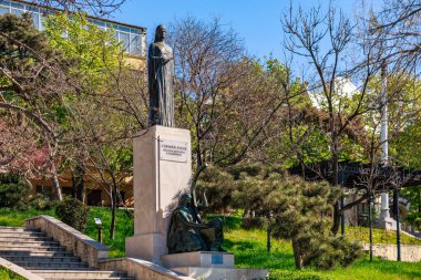 Carmen Sylva 'nın ilkbahar heykeli ağaçlar ve merdivenlerle dolu bir parkta. 3 Mayıs 2025 Romanya.