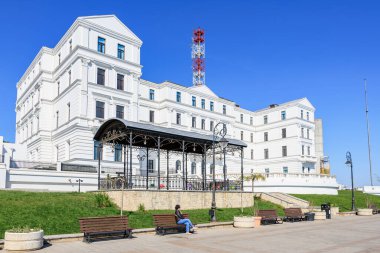 Açık bir günde bankları olan büyük beyaz bir bina. 3 Mayıs 2025 Romanya.