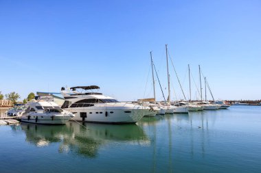 Güneşli bir marinaya demirlemiş lüks yatlar ve yelkenliler. 3 Mayıs 2025 Romanya.