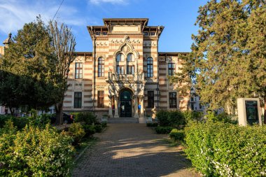 Kemerli girişi ve simetrik tasarımı olan tarihi İtalyan mimarisi. 3 Mayıs 2025 Romanya.