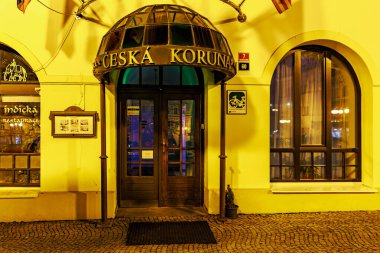 Ceska Koruna restoranının gece girişi, kaldırım taşı yolu var. 16 Mart 2025, Decin, Çek Cumhuriyeti.