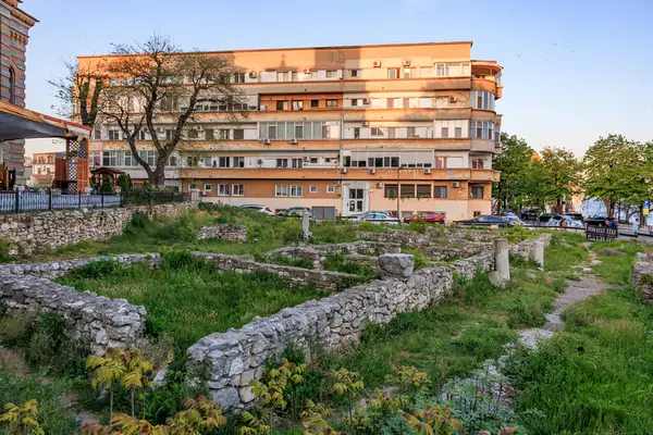 Günbatımında modern mimarisi olan antik Roma harabeleri. 3 Mayıs 2025 Romanya.