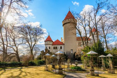 Tarihsel bereketli bahçe ve kırmızı çatıları olan ortaçağ şatosu. 17 Mart 2025, Konopiste Şatosu, Çek Cumhuriyeti.