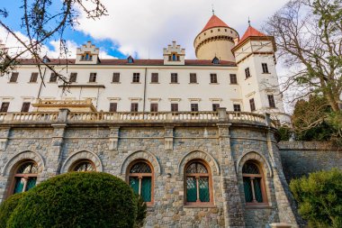 Taş cepheli ve yemyeşil kuleleri olan görkemli Avrupa kalesi. 17 Mart 2025, Konopiste Şatosu, Çek Cumhuriyeti.