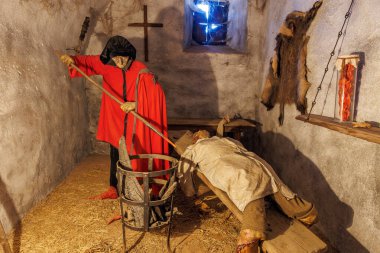 Medieval dungeon scene with torture devices and figures in historical costume. March 18, 2025, Loket, Czech Republic.