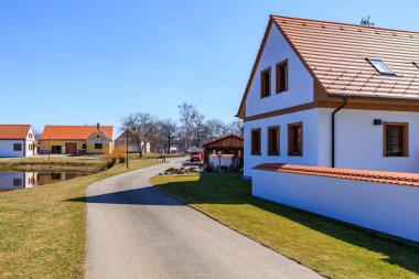 Idyllic rural village scene with traditional european houses and clear blue sky. March 21, 2025, Holasovice, Czechia.