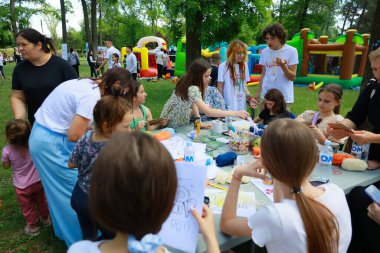 Community art event with diverse adults and children engaging in outdoor activities. May 31, 2024 Balti Moldova.