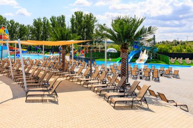 A beach with a lot of lounge chairs and umbrellas. The chairs are spread out and the umbrellas are open. June 8, 2024 Balti Moldova
