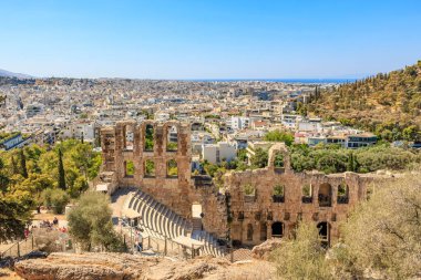 Arkasında büyük bir bina olan bir şehir manzarası. Şehir insanlarla dolu ve gökyüzü açık. 9 Ağustos 2024 Atina Yunanistan
