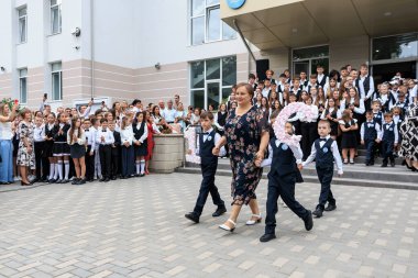 School ceremony with diverse group of children and adults in formal attire. September 2, 2024 Balti Moldova.