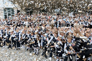 Joyful school celebration with confetti and smiling children outdoors. September 2, 2024 Balti Moldova.