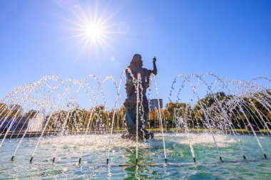 A statue of a man is in a fountain with water spraying from it. The sun is shining brightly, creating a beautiful and peaceful atmosphere. October 27, 2024 Chisinau Moldova