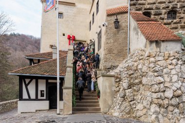 Group of people are walking up a set of stairs. December 16, 2024 Bran Romania.