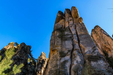 Majestic rock formations under clear blue sky in remote mountainous terrain.