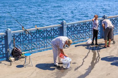 Sunny day fishing on waterfront: diverse group engaged in outdoor activity. August 12, 2025 Istanbul Turkey.