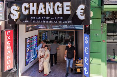 Currency exchange storefront with diverse group of adults in urban setting. August 12, 2025 Istanbul Turkey.