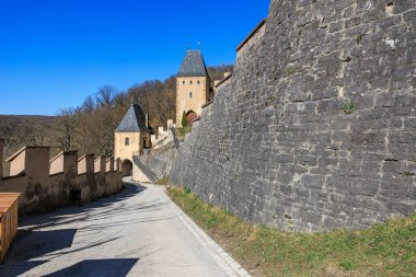 Medieval castle walls and towers under clear blue sky.