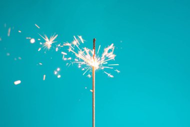 Mavi arka planda Bengal ışıkları. Bengal ışığı, parlak renk. Uzayı kopyala Şenlik arkaplanının odak noktasını kaldır. Noel ışıltıları