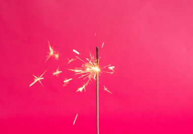 Pembe arka planda Bengal ışıkları. Parlak renkte maytap. Uzayı kopyala Şenlik arkaplanının odak noktasını kaldır. Noel ışıltıları