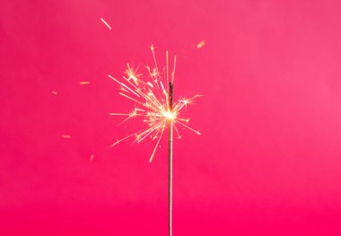 Pembe arka planda Bengal ışıkları. Parlak renkte maytap. Uzayı kopyala Şenlik arkaplanının odak noktasını kaldır. Noel ışıltıları