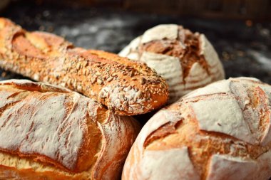 Hasır sepetteki fırın ürünleri. Yuvarlak ev yapımı ekmek, tohumlu uzun somun, mayasız vejetaryen ekmeği..