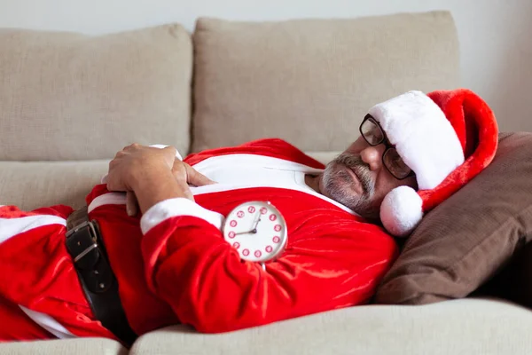 Noel Baba Kılığındaki Yaşlı Adam Çalar Saatin Yanındaki Kanepede Uyuyor — Stok fotoğraf