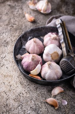 Taş masa arkasında taze organik sarımsak.