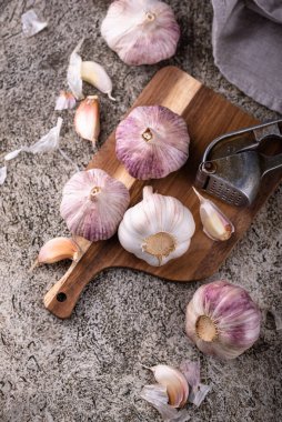 Taş masa arkasında taze organik sarımsak.