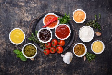 Farklı soslar seti. Ketçap, hardal, mayonez, pesto, marinara, adjika ve peynir sosu.
