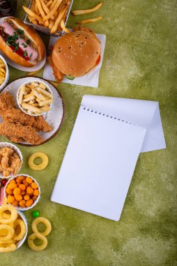 Sağlıksız abur cubur çeşitleri. Hamburger, patates kızartması, sosisli sandviç, atıştırmalık ve tatlı.